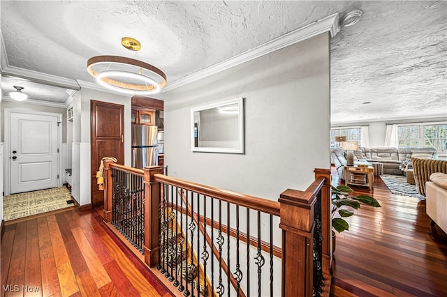 corridor featuring a textured ceiling, dark hardwood / wood-style floors, and crown molding