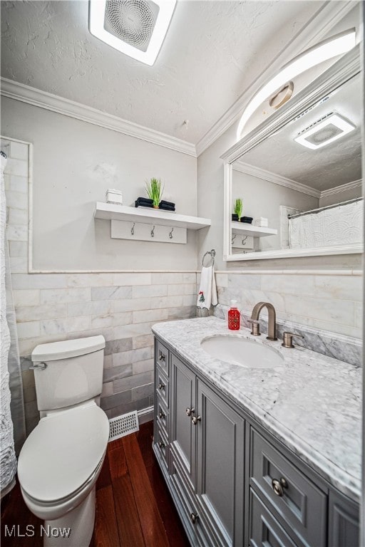 bathroom with hardwood / wood-style flooring, toilet, crown molding, and tile walls