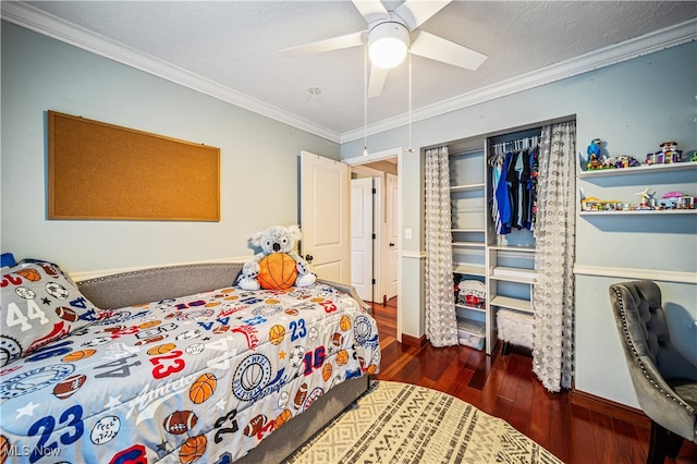 bedroom featuring ceiling fan, dark hardwood / wood-style flooring, ornamental molding, and a closet