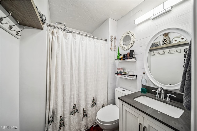 bathroom featuring a textured ceiling, vanity, and toilet