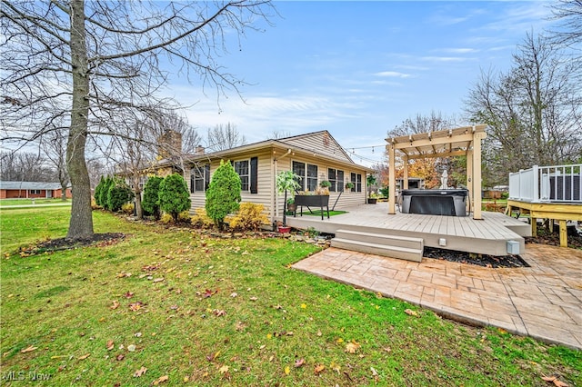 rear view of property with a lawn, a wooden deck, a pergola, and a hot tub