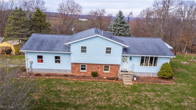 rear view of house featuring a yard