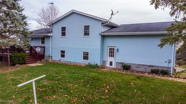 back of house featuring a lawn and a wooden deck