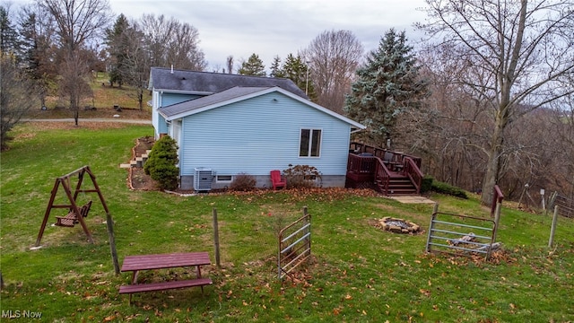 view of property exterior with cooling unit, a yard, and a wooden deck