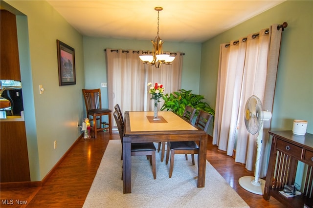 dining space with a chandelier and dark wood-type flooring