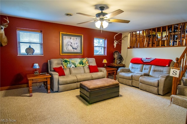 living room featuring carpet floors, ceiling fan, and a healthy amount of sunlight