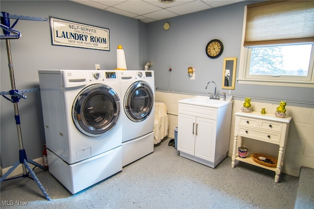 laundry room featuring cabinets, independent washer and dryer, and sink