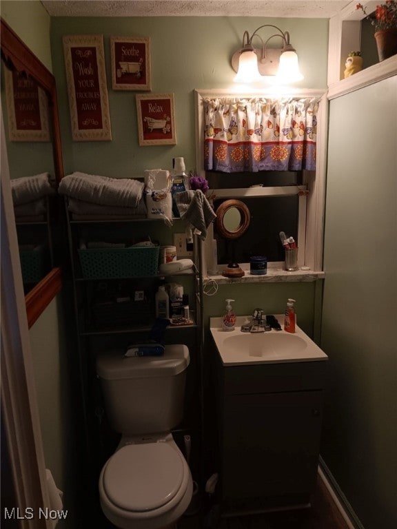 bathroom with vanity, a textured ceiling, and toilet