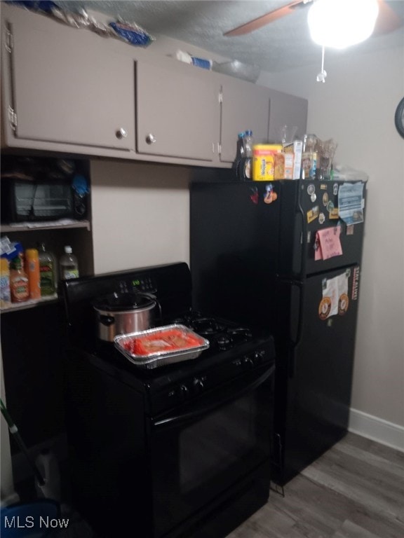 kitchen with black appliances, ceiling fan, white cabinets, and light hardwood / wood-style flooring