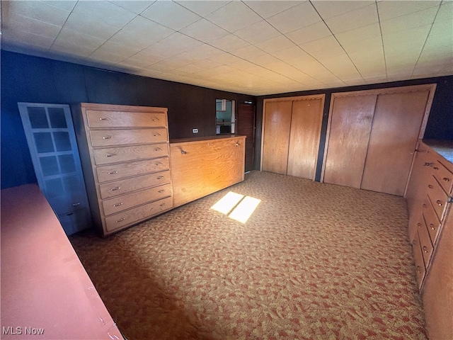 unfurnished bedroom with carpet and two closets