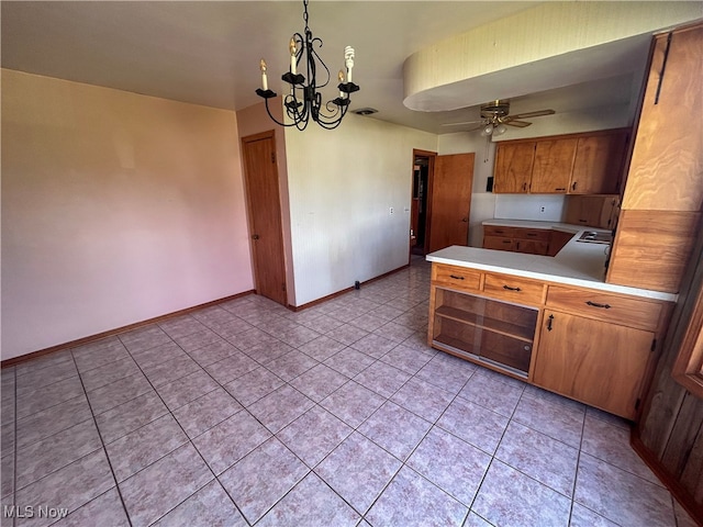 kitchen featuring kitchen peninsula, light tile patterned flooring, hanging light fixtures, and ceiling fan with notable chandelier