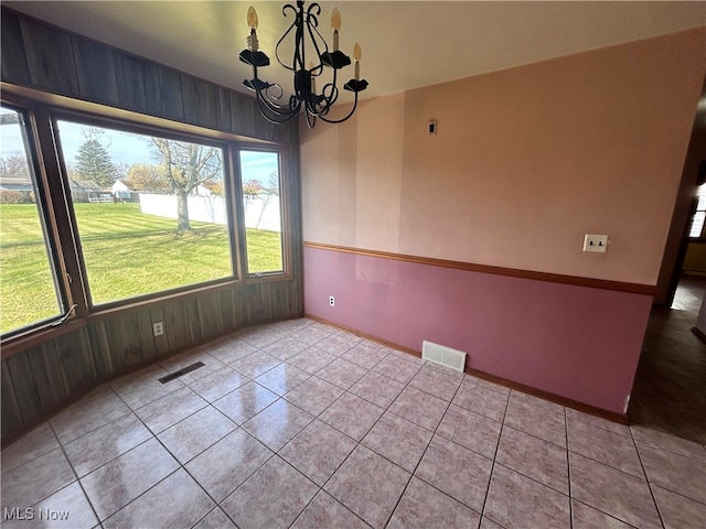 unfurnished dining area with a chandelier and light tile patterned floors