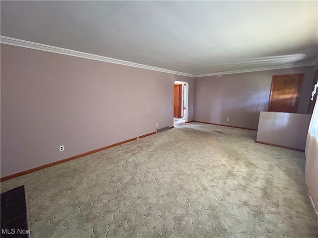 spare room featuring light carpet and crown molding