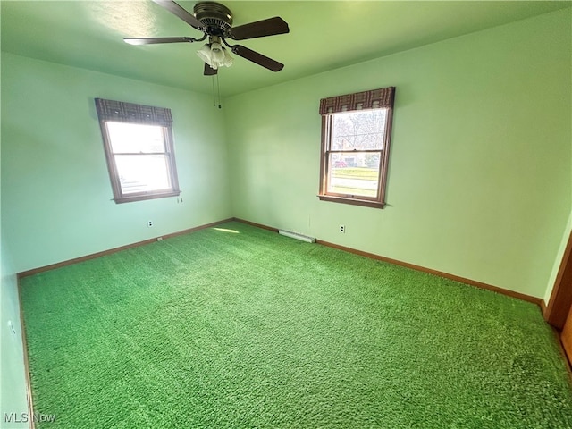 unfurnished room with plenty of natural light, ceiling fan, carpet floors, and a baseboard radiator