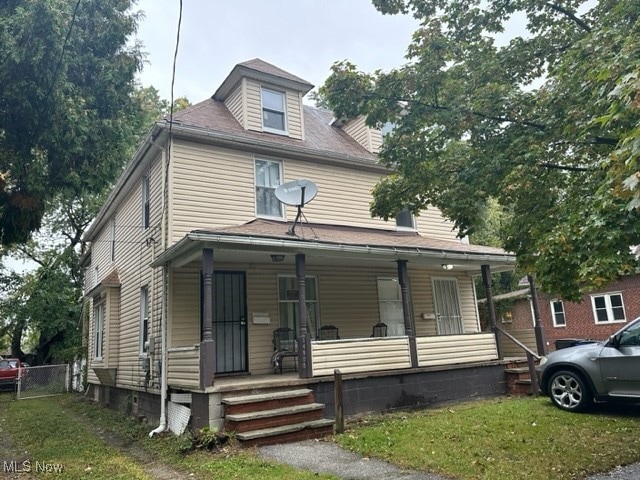 view of front of house featuring covered porch and a front yard