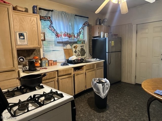 kitchen featuring stainless steel fridge, gas range gas stove, and light brown cabinetry