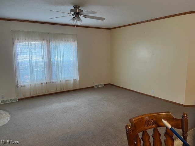 unfurnished room with ceiling fan, crown molding, carpet floors, and a textured ceiling