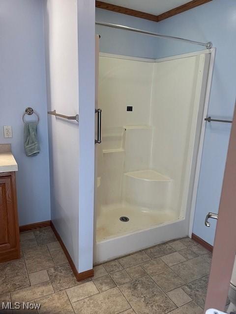 bathroom with vanity, a shower, and crown molding