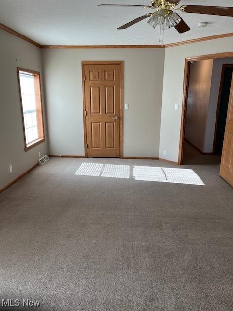 carpeted empty room featuring ceiling fan and ornamental molding