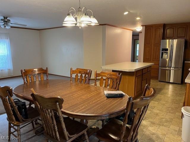 dining area featuring crown molding and ceiling fan with notable chandelier