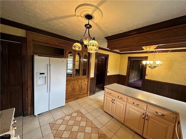 kitchen with white refrigerator with ice dispenser, an inviting chandelier, a textured ceiling, decorative light fixtures, and light tile patterned flooring