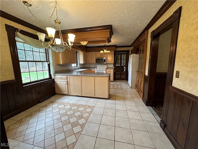 kitchen featuring sink, white appliances, hanging light fixtures, and an inviting chandelier