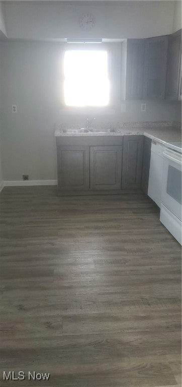 kitchen featuring white appliances, sink, and dark wood-type flooring