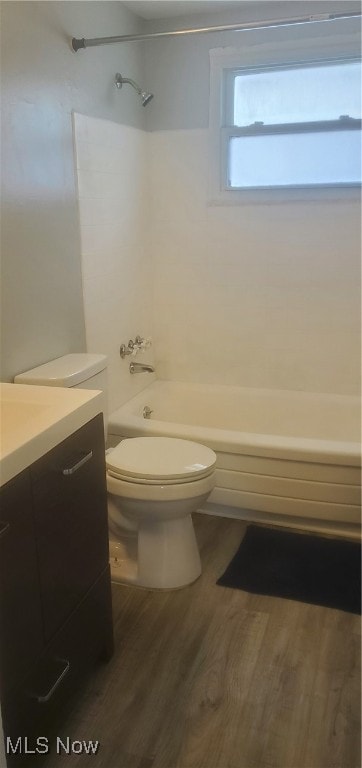 full bathroom with shower / bathing tub combination, wood-type flooring, vanity, and toilet