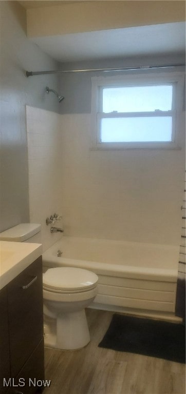 full bathroom featuring hardwood / wood-style flooring, vanity, toilet, and shower / washtub combination