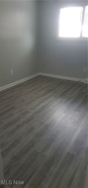 spare room with dark hardwood / wood-style floors