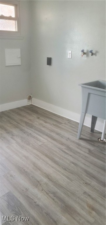 clothes washing area with light wood-type flooring