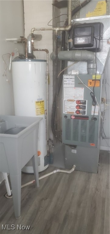 utility room featuring heating unit and water heater