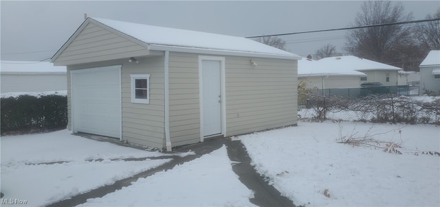 snow covered structure featuring a garage