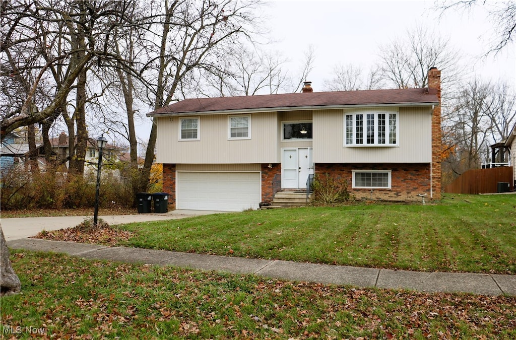 bi-level home with a front yard and a garage