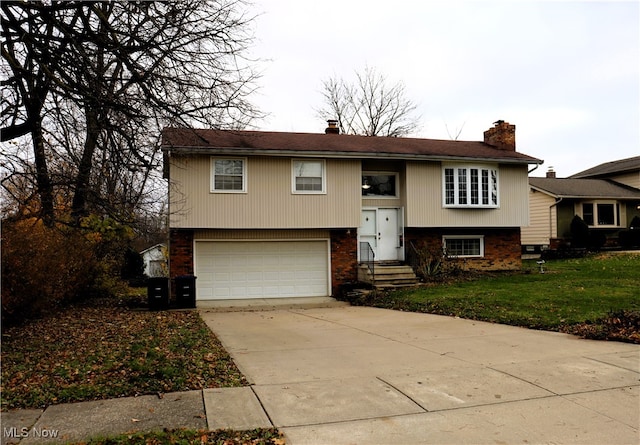 raised ranch with a front yard and a garage