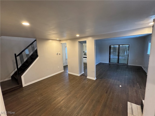 unfurnished living room with dark wood-type flooring