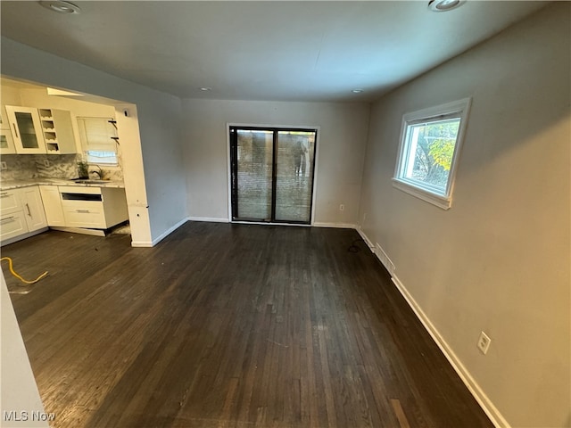 unfurnished living room with sink and dark wood-type flooring