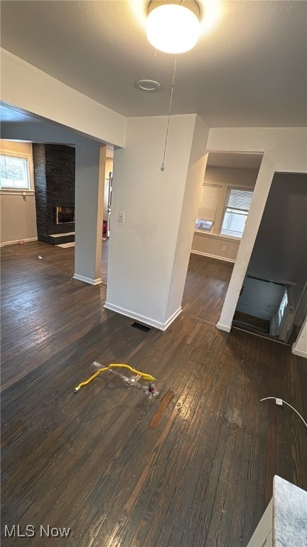 unfurnished living room featuring dark hardwood / wood-style floors, a healthy amount of sunlight, and a fireplace