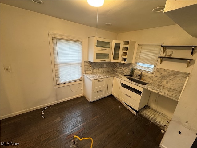 kitchen with white cabinets, dark hardwood / wood-style flooring, light stone counters, and sink