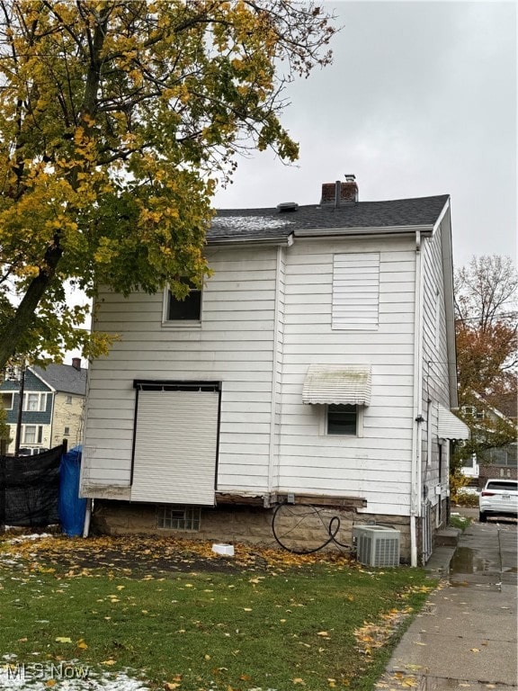 view of side of home featuring central air condition unit and a yard