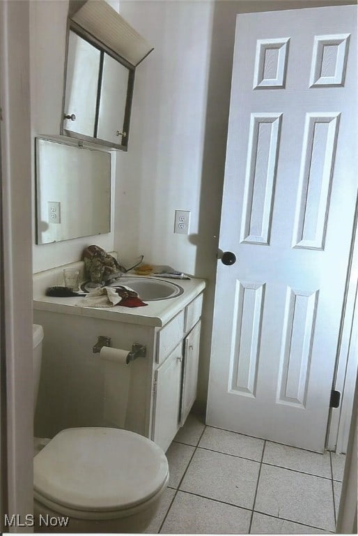 bathroom featuring tile patterned floors, vanity, and toilet