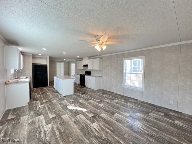 kitchen with sink, black appliances, a center island, dark hardwood / wood-style floors, and white cabinetry