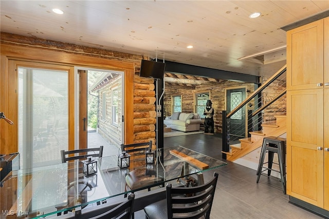 dining room with wood ceiling, rustic walls, and dark wood-type flooring