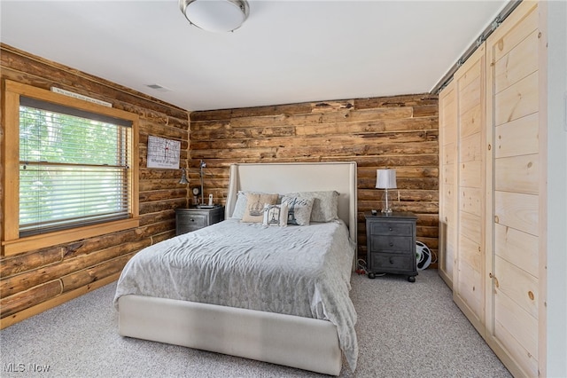 bedroom featuring light colored carpet and wooden walls