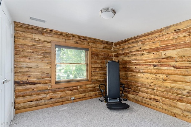 workout room featuring carpet and wooden walls