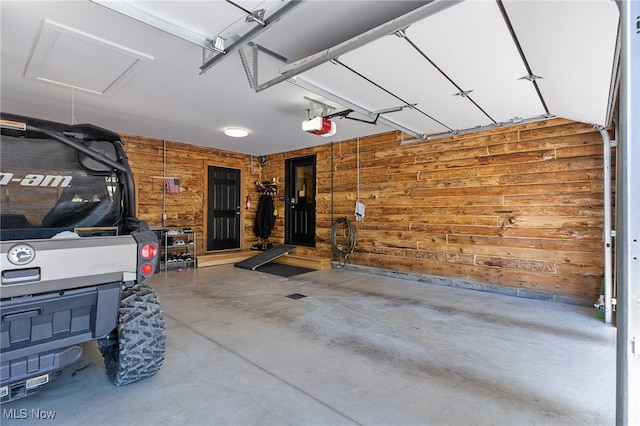 garage featuring wooden walls and a garage door opener