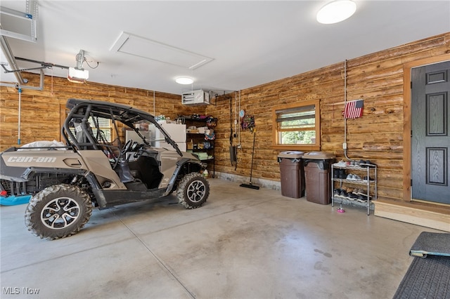 garage featuring wooden walls and a garage door opener