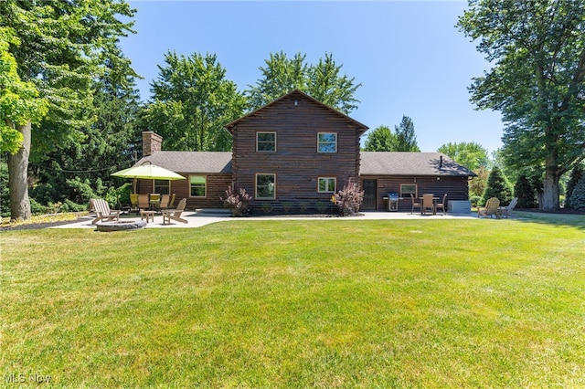 rear view of house featuring a patio, a fire pit, and a lawn