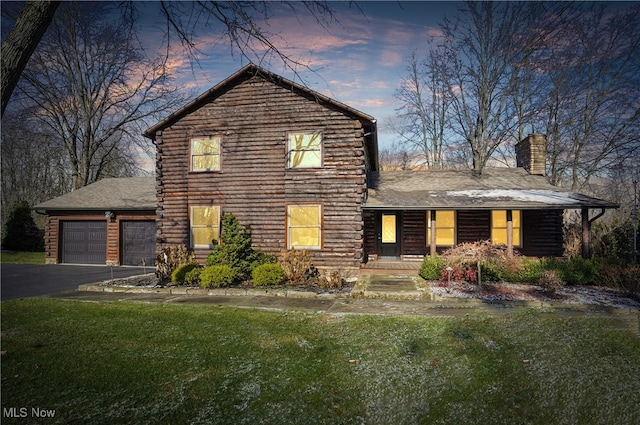 view of front of home with a yard and a garage