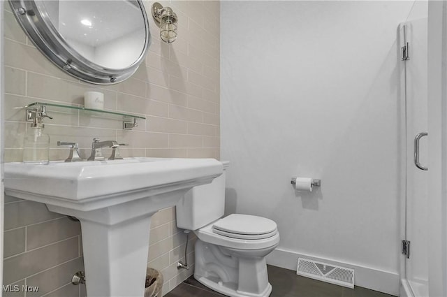 bathroom featuring decorative backsplash, toilet, and tile walls